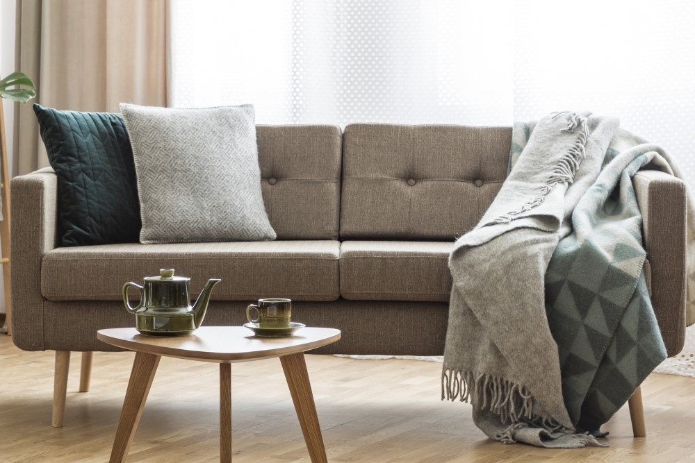 Sofa med puder og tæppe på